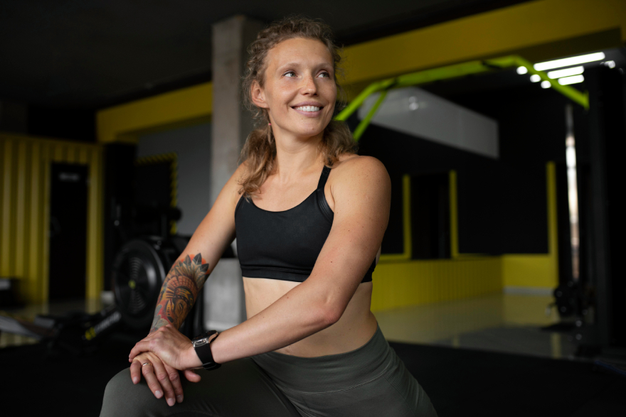 Best peptides for weight loss: a woman smiling and training in the gym.