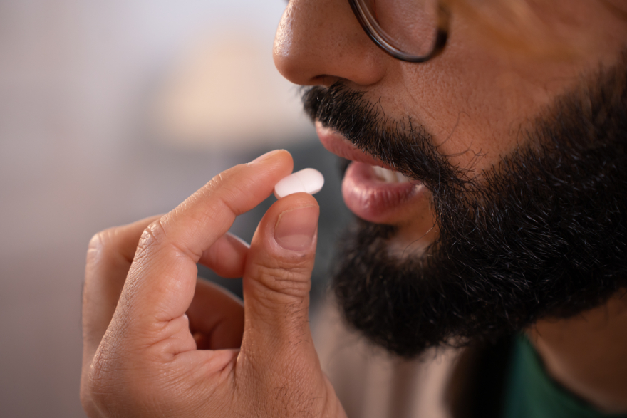 Collagen peptides benefits: a man taking a pill.