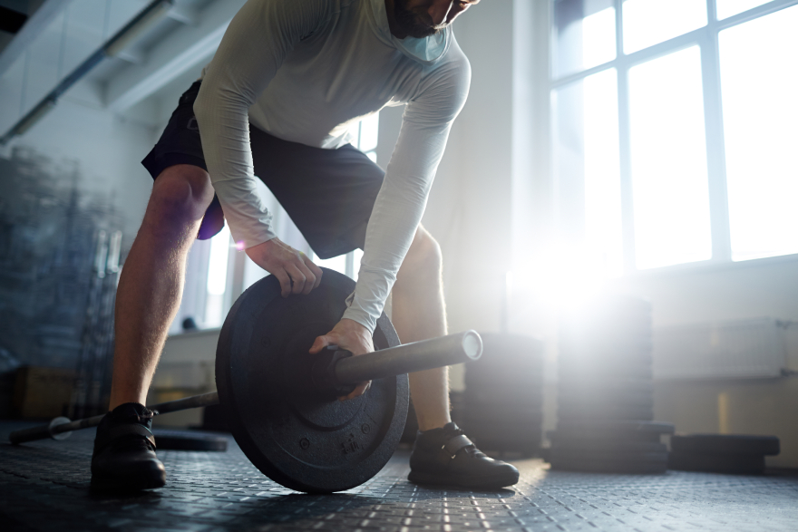 Collagen peptides benefits: a man lifting weights.