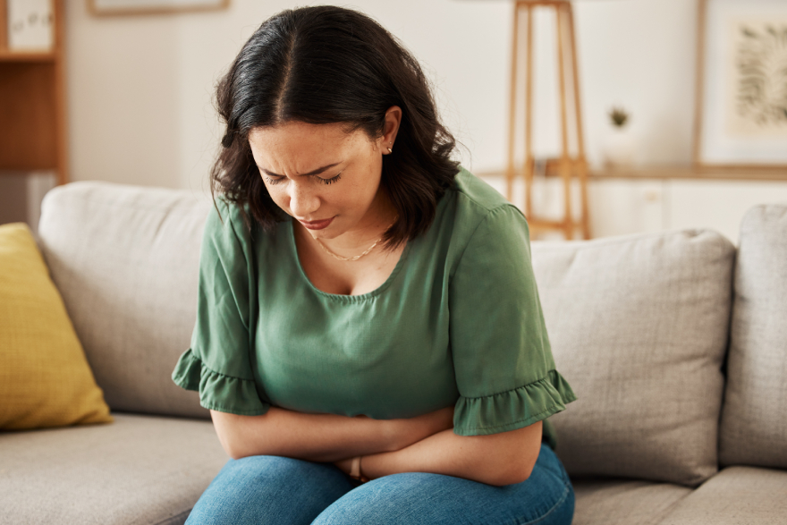 Collagen peptides benefits: a woman feeling bloated.