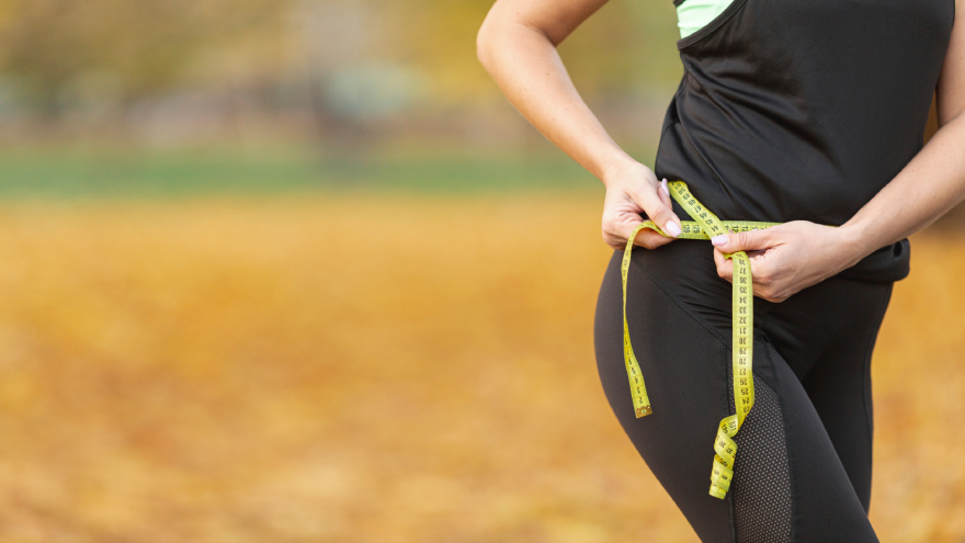 Ozempic alternatives: a woman measuring her waist.