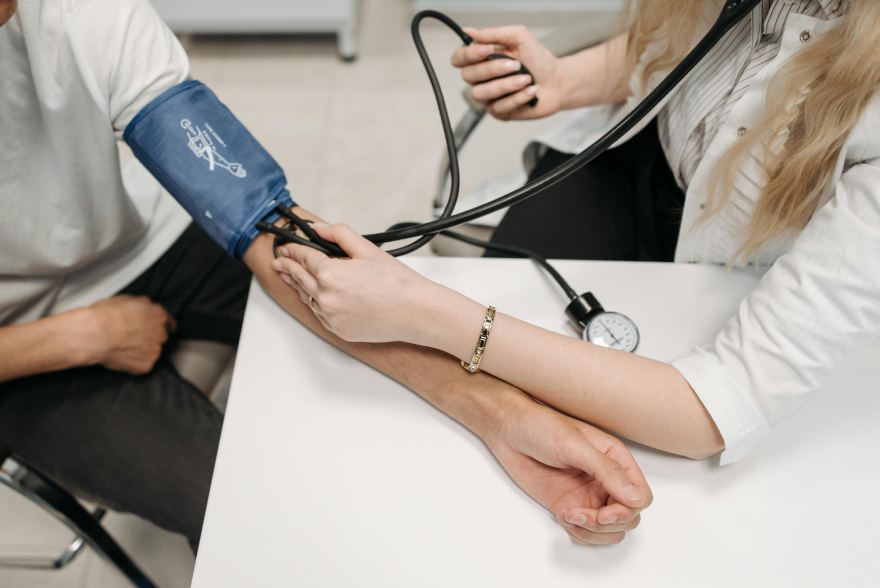 Sauna benefits: a doctor measuring a patient's blood pressure.
