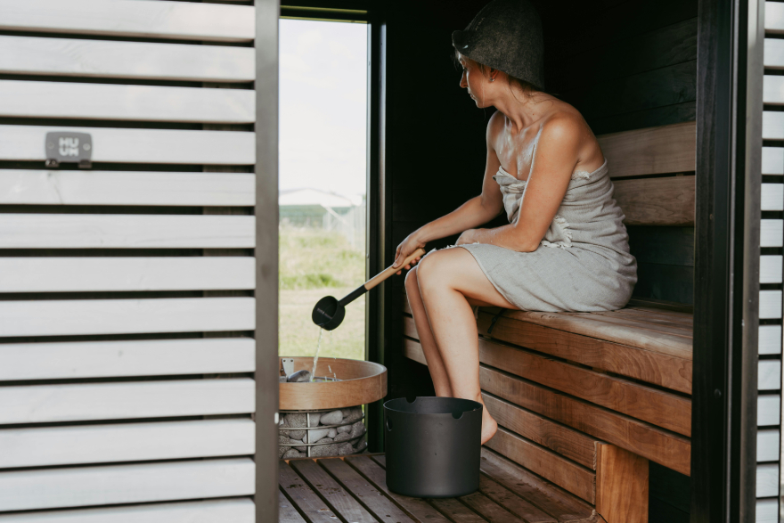 Sauna benefits: a woman sitting in a sauna.