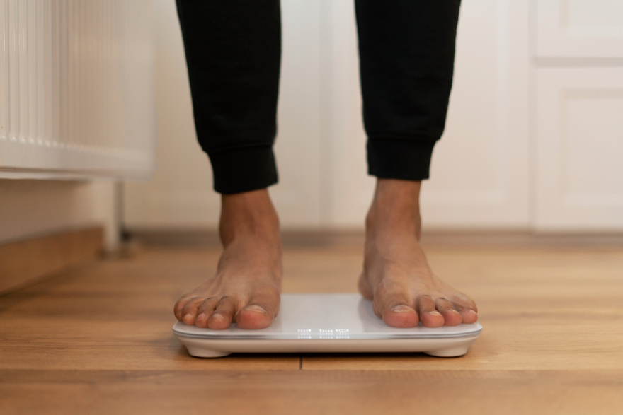 Wegovy vs Mounjaro: a person on scales.