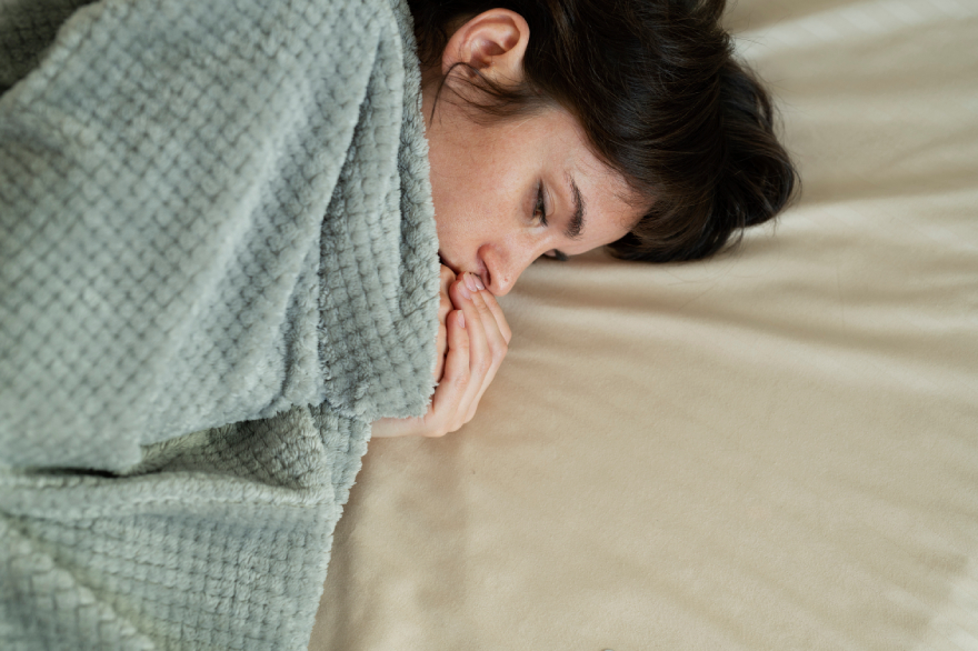 Wegovy vs Mounjaro: a woman lying in bed, sick.